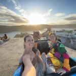 Pessoa em cima de um buggy azul durante o passeio de buggy em Búzios com a Búzios Trip Tour apreciando um belo por do sol
